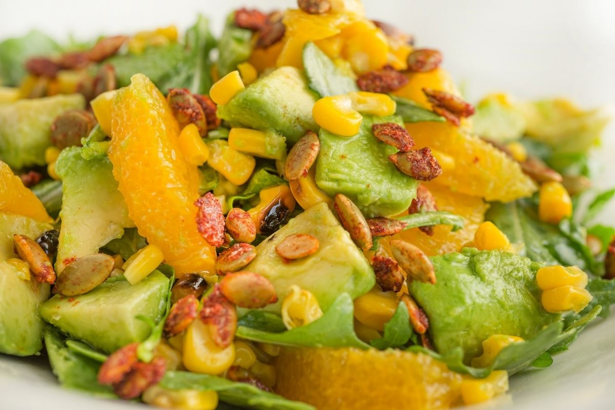 Bold and crisp close up photo of the salad showcasing the juicy mandarins and avocado with crunchy toppings.