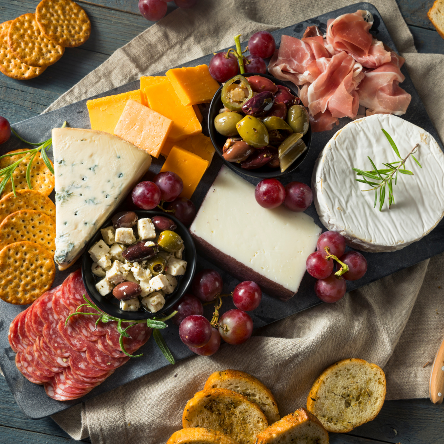 Charcuterie board with various meats, cheeses, and other accompaniments